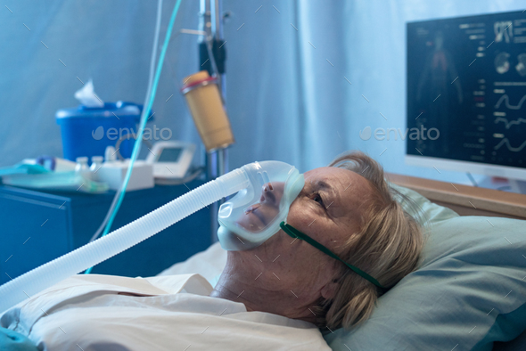 Close-up of covid-19 patient in bed in hospital, coronavirus and ventilation concept.