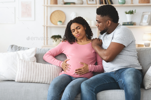 Black pregnant woman suffering from labor pains at home