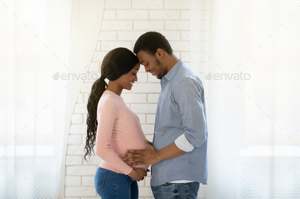 Handsome Black Man Touching His Pregnant Wifes Belly Indoors Side