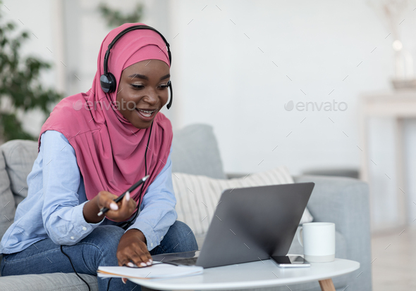 Online Tutoring. Friendly black muslim female tutor having video call with students