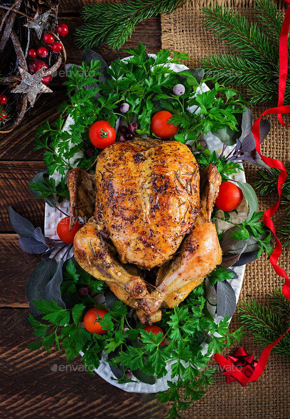 Baked turkey or chicken. The Christmas table is served with a turkey, decorated with bright tinsel. Fried chicken, table setting. Christmas dinner. Top view, overhead, copy space