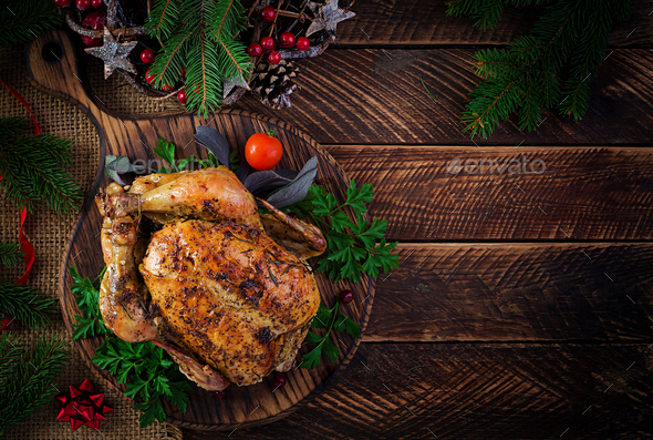 Baked turkey or chicken. The Christmas table is served with a turkey, decorated with bright tinsel. Fried chicken, table setting. Christmas dinner. Top view, overhead, copy space