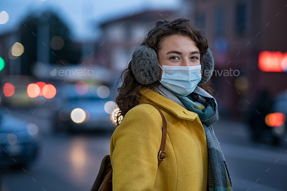 Portrait of woman with sunglasses and protective mask in city