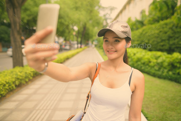 Young beautiful Asian tourist woman exploring Ho Chi Minh city in Vietnam - Stock Photo - Images