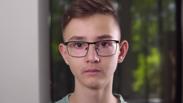 Caucasian Upset Young Boy is Looking at Camera at Home Close Up Front Portrait