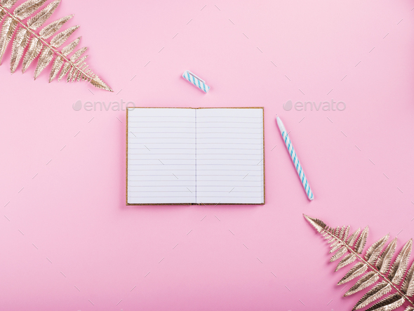 Mockup blank paper notebook and green leaf on a gray background