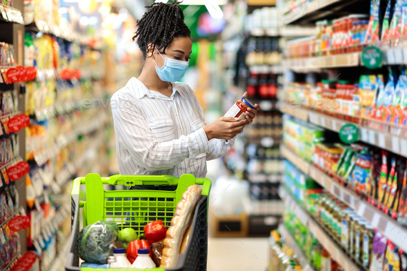 Black Woman Holding Food Product Doing Grocery Shopping In Supermarket