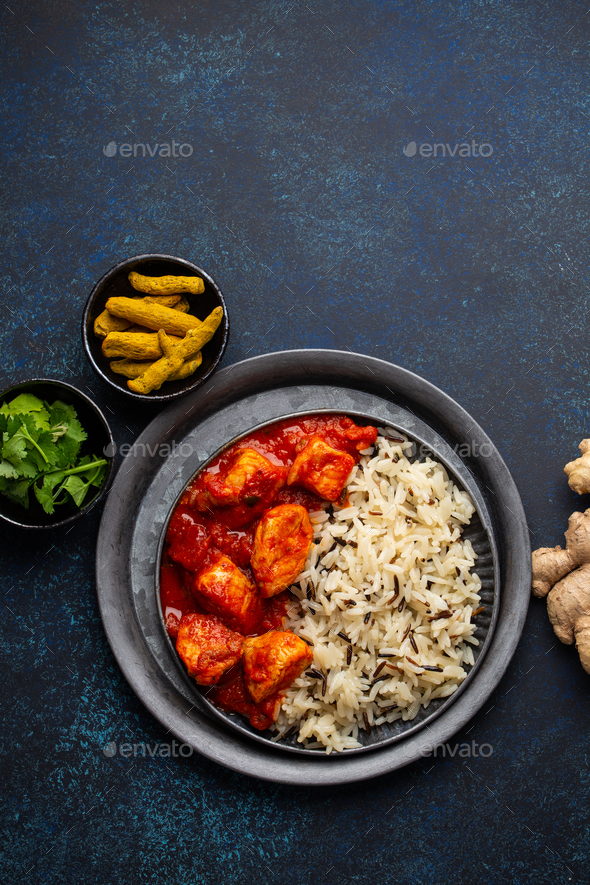 Chicken tikka masala dish with rice, flat Indian bread and spices - Stock Photo - Images