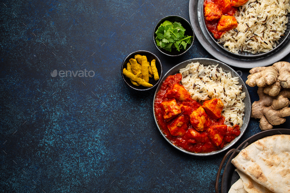 Chicken tikka masala dish with rice, flat Indian bread and spices - Stock Photo - Images