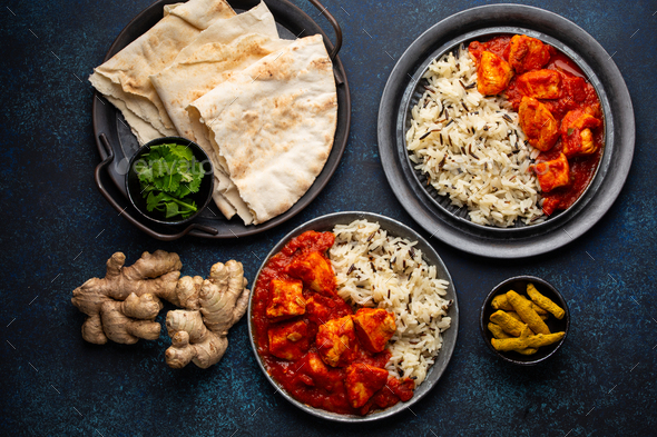 Chicken tikka masala dish with rice, flat Indian bread and spices - Stock Photo - Images