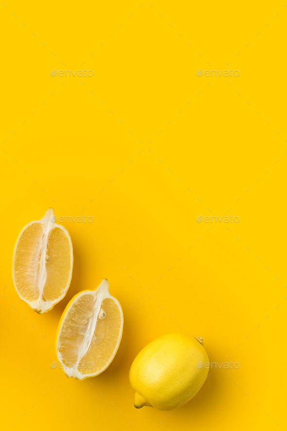 Two halves of lemon and single lemon isolated on yellow