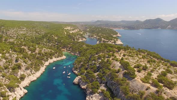 Aerial travel drone view of clear green water, cliffs of Cassis, Mediterranean Sea, Southern France. alt