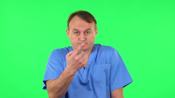 Medical Man Throwing Up Hands Expressing He Is Innocent, Twists His Finger at His Temple. Green alt