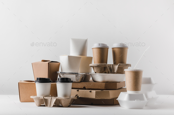 pizza boxes and disposable coffee cups with take away boxes on tabletop