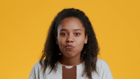 Happy African American Teenager Girl Eating Chocolate Over Yellow Background alt