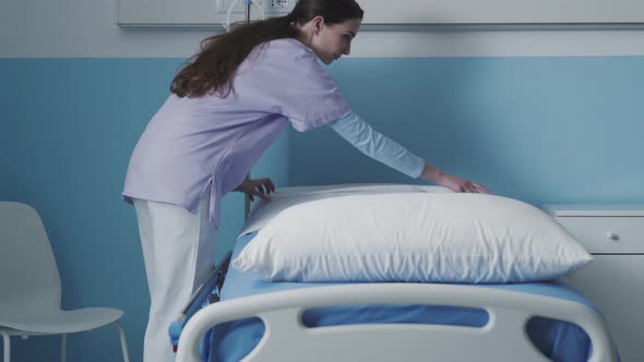 Expert nurse making the bed at the hospital