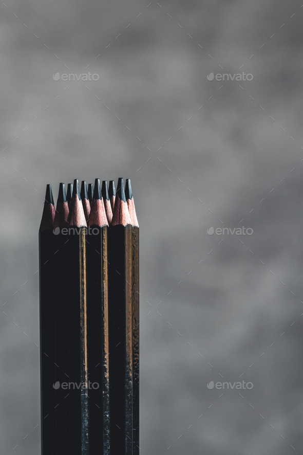 Simple graphite pencils on grey background. Black pencils, space for text  Stock Photo by serbogachuk