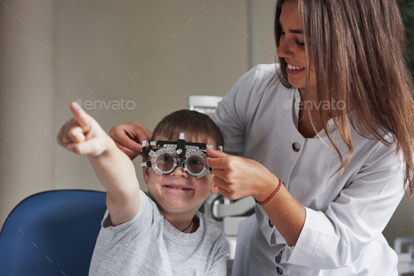 Smiling and reading. Child sitting in the doctor\'s cabinet and have tested his visual acuity