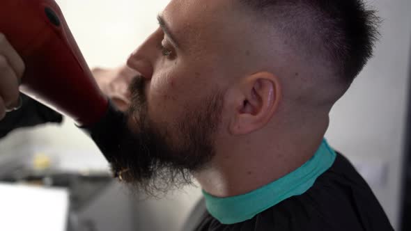 Handsome Bearded Man is Getting Beard Styling at the Barbershop alt