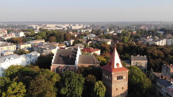 Aerial drone view of Drohobych town. Aerial flyover near ancient Сathedral and Bell Tower, zoom in alt