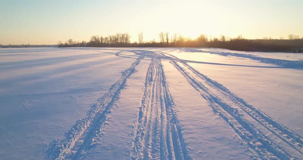 Snowmobile tracks and sunset