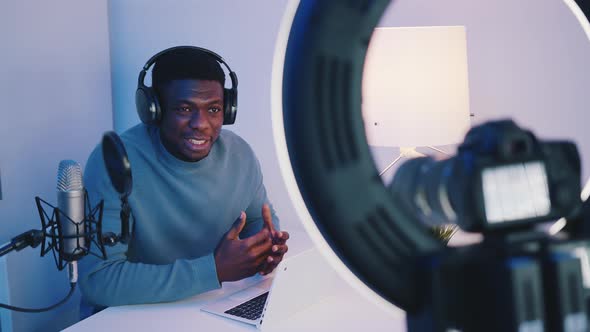 African American Wearing Headphones Explaining Something  Looking At The Camera alt