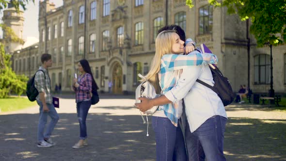 Multiracial classmates embracing, happy to see each other after holidays alt