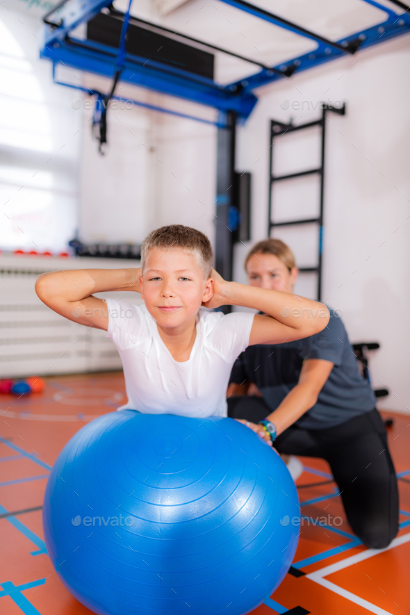 Children during physical activity class, exercising with fitness balls