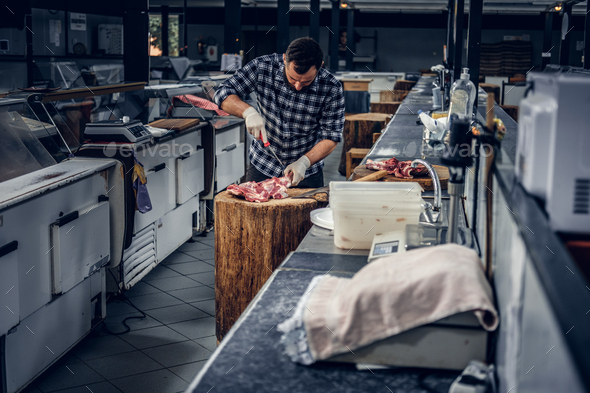 Bearded butcher cut fresh meat. Stock Photo by fxquadro | PhotoDune