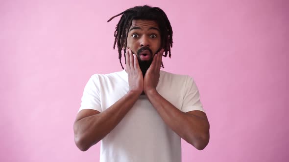 Emotion of astonishment, modern man with dreadlocks on pink background alt