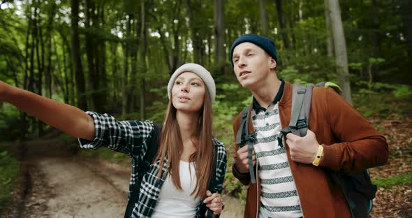 Couple of Backpacked Tourists Choosing Path