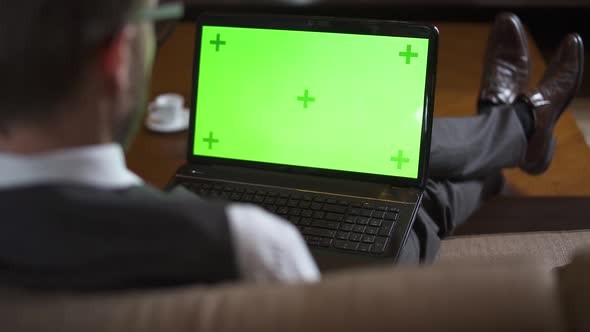 Businessman in Glasses Working at a Laptop with Chroma Key Screen Man in the Suit Sitting on the alt