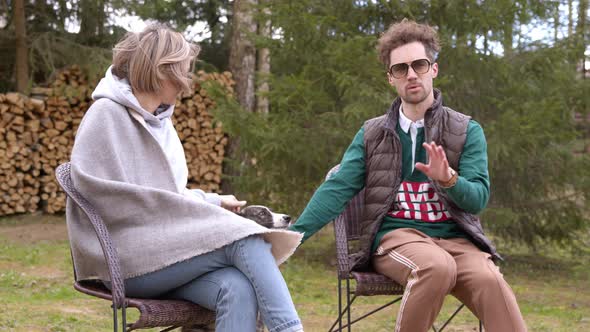 Couple of Lovers Spend Time Outdoors with Dog in Windy Weather. Girl in Blanket