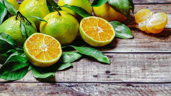 Green mandarins on wooden background, copy space - Stock Photo - Images