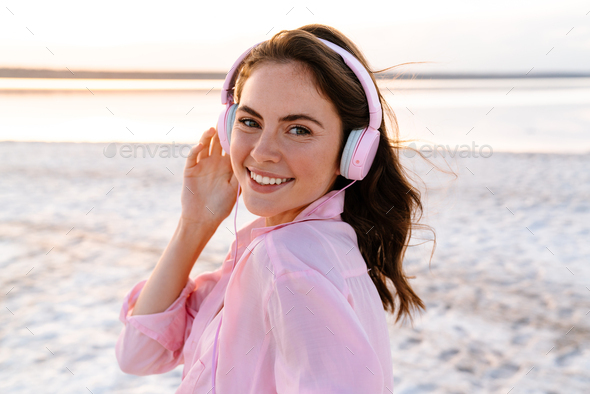 Cheery pleased young girl in sunglasses listening music - Stock Photo - Images