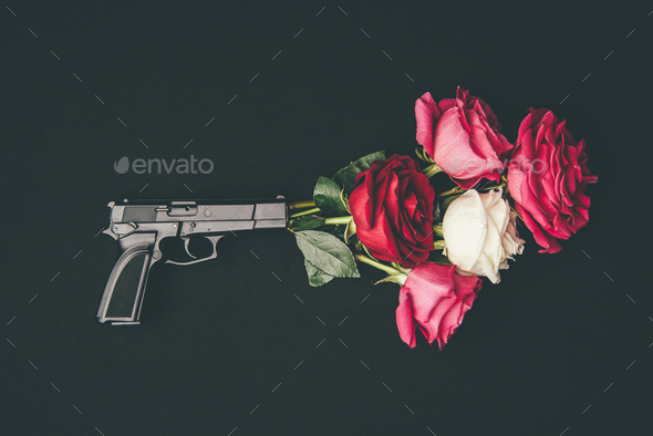 Gun shooting with bouquet of rose flowers isolated on black