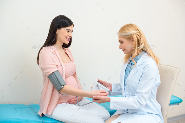 Obstetrician Gynecologist Measuring Blood Pressure Of Pregnant Woman ...