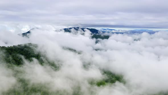 Flying through the clouds above the mountain peak.