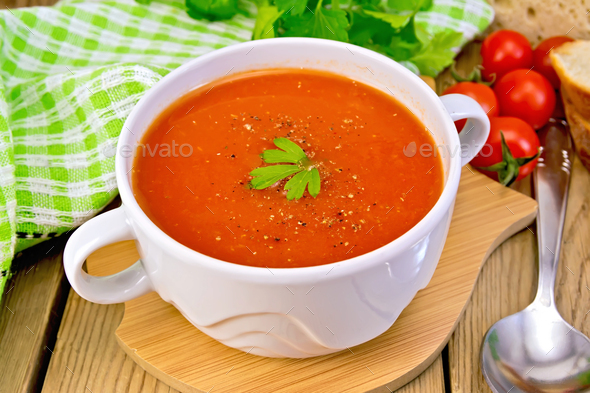 Soup tomato in bowl with spoon on board - Stock Photo - Images