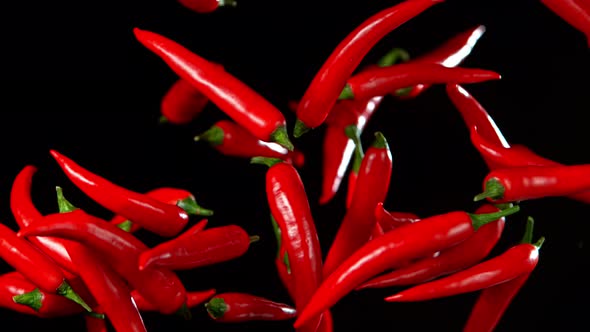 Super Slow Motion Shot of Flying Red Chilli Peppers in the Air at 1000Fps alt