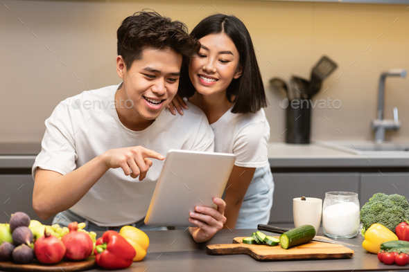 Korean Husband And Wife Cooking Using Digital Tablet In Kitchen Stock ...