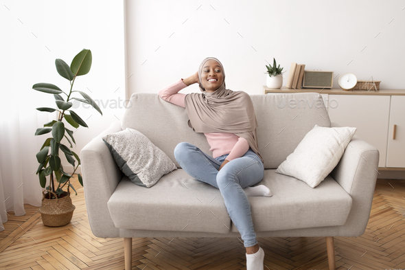 Full Length Portrait Of Black Woman In Hijab Resting On Comfy Couch At Home Stock Photo By Prostock Studio