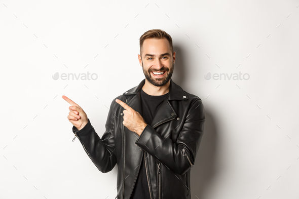 Confident macho man in black leather jacket, pointing fingers left at promo offer, showing logo