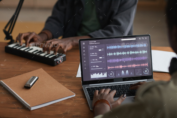 African-American Man Making Music via Laptop