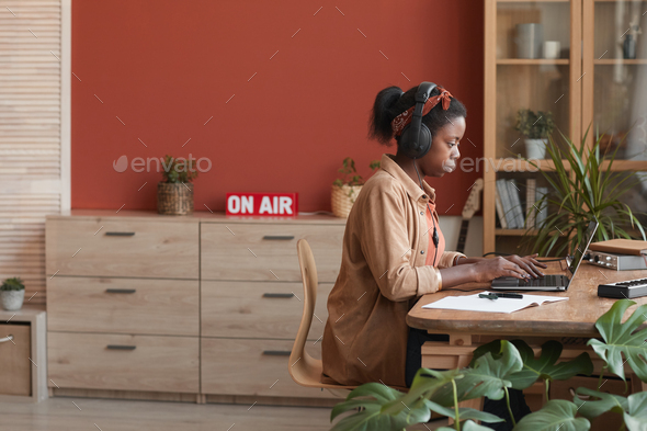 Female African-American Musician Editing Music via Laptop