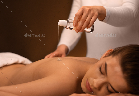 Body care. Relaxed woman enjoying back massage Stock Photo by