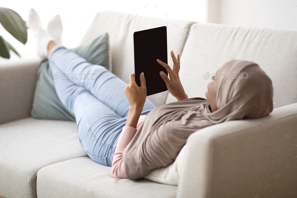 Download African American Woman In Hijab With Tablet Computer Lying On Sofa At Home Mockup For Design On Stock Photo By Prostock Studio