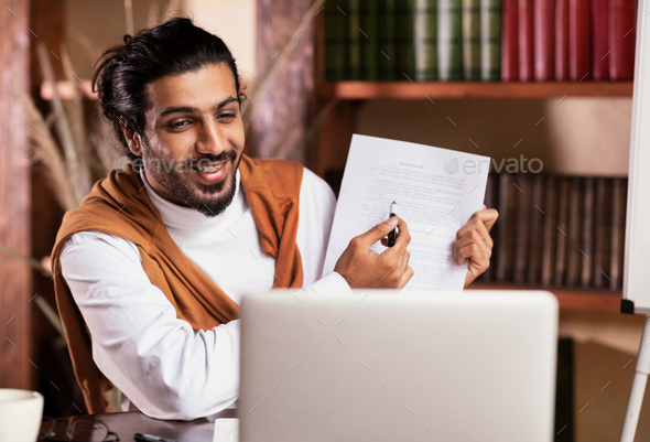 Indian Teacher At Laptop Having Class Teaching Online Sitting Indoors