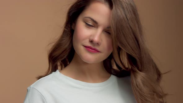 Monochrome Natural Makeup Look Caucasian Woman in Studio with Brunette Wavy Hair Blowing alt