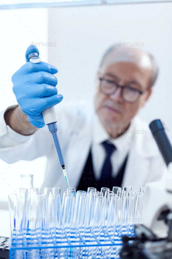 Scientist with protection gear using dropper pipette